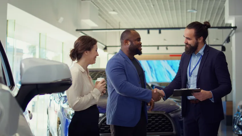 car salesperson dealership signing contract with clients shaking hands 1